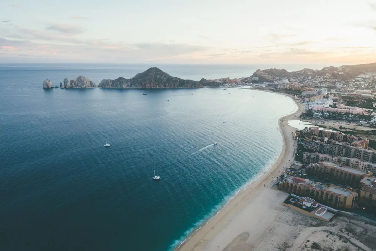 An aerial view of Cabo San Lucas bay and Médano Beach at sunset