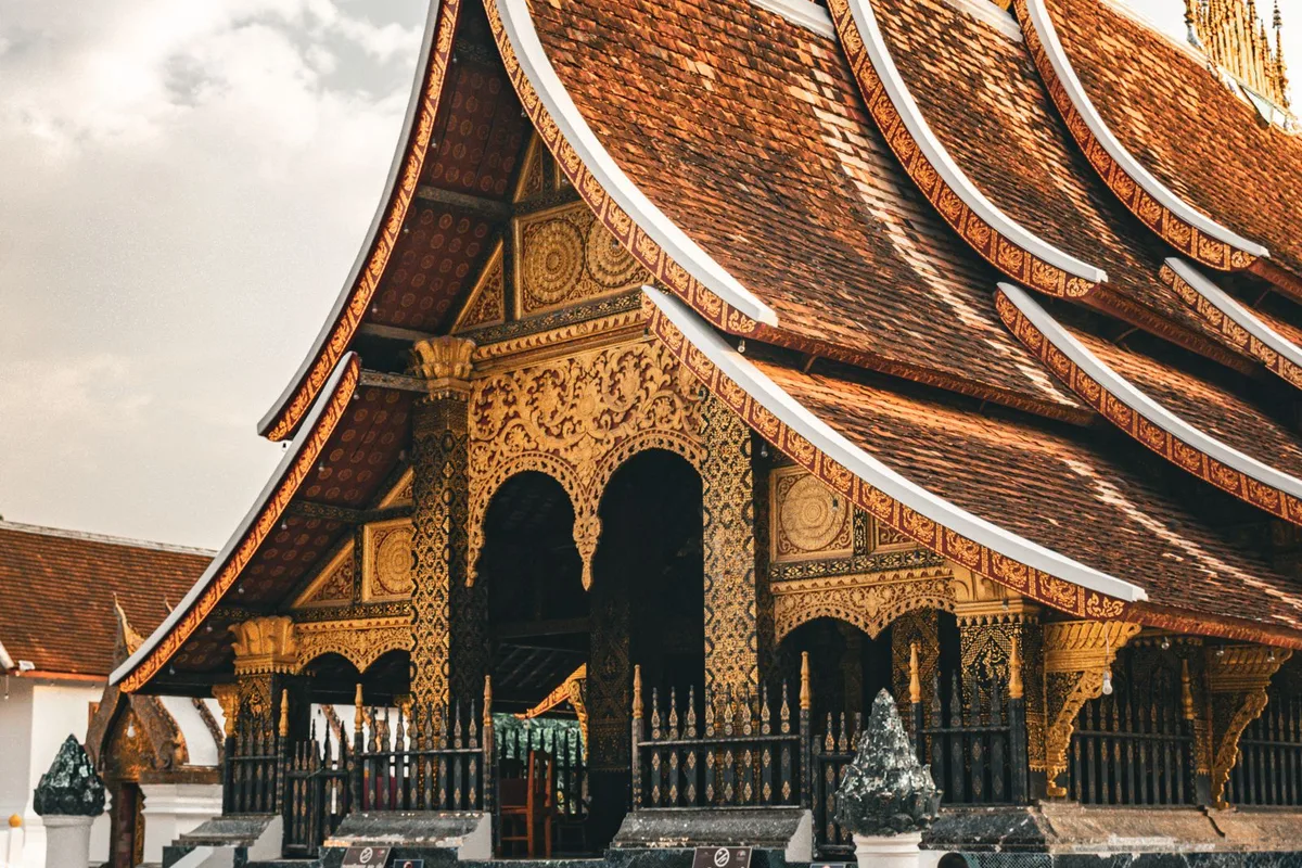 The golden sim of Wat Xieng Thong in Luang Prabang, its sweeping roofs almost touching the ground