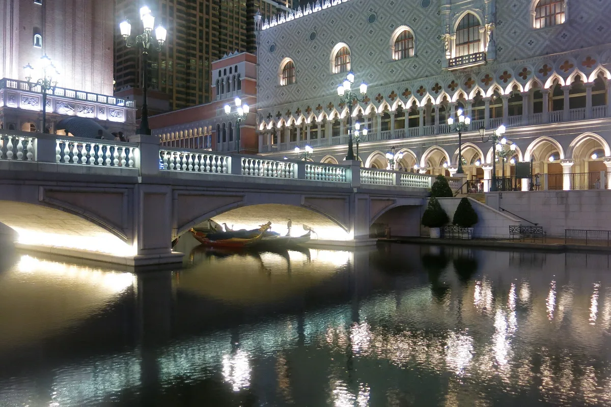 The Venetian Macao across its canal at night, a gondola on the water