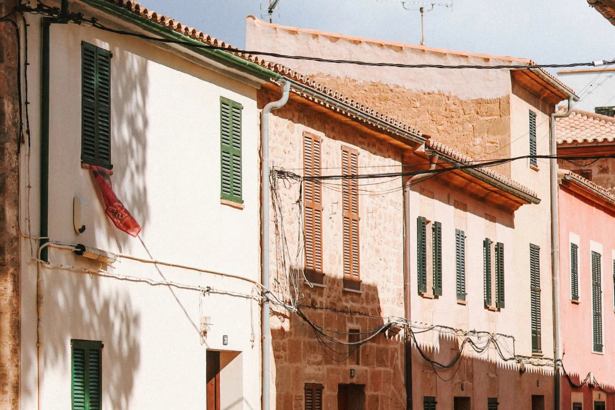 A quiet old town street in Palma with shuttered stone houses