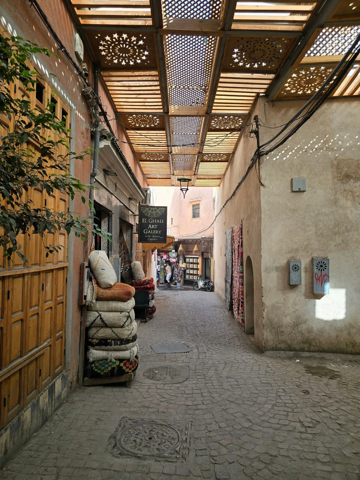 A carpet shop in a shaded souk passage