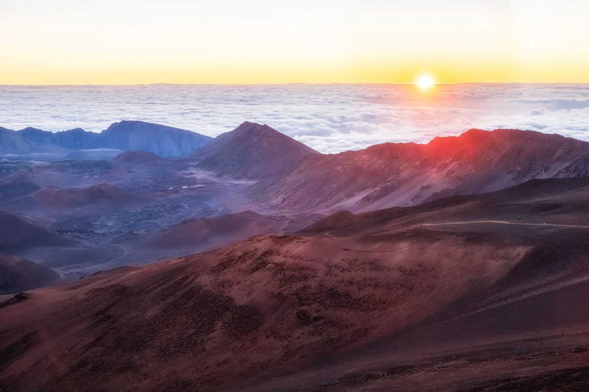 Sunrise breaking over the Haleakala crater above a sea of cloud