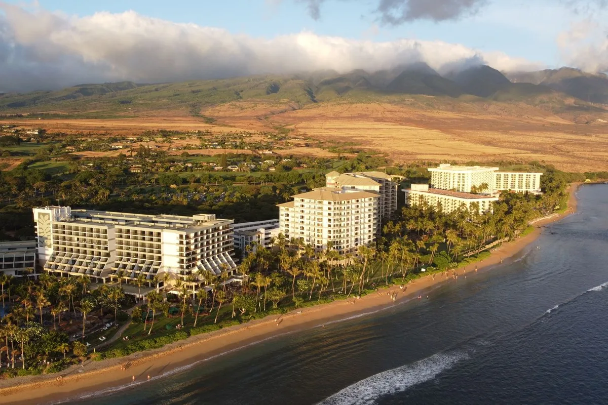 Resort hotels along the sweep of Kaanapali Beach from the air at sunset