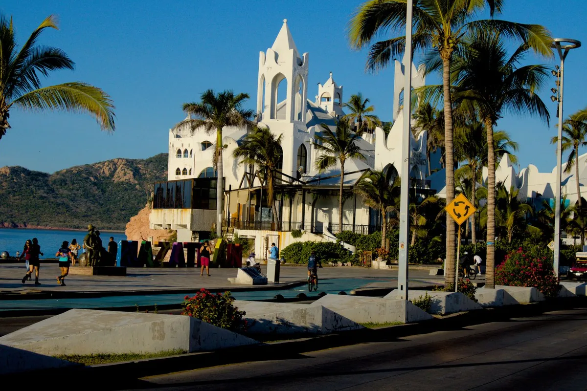 The white Valentinos complex on the Mazatlán malecón, palms in front and the bay behind