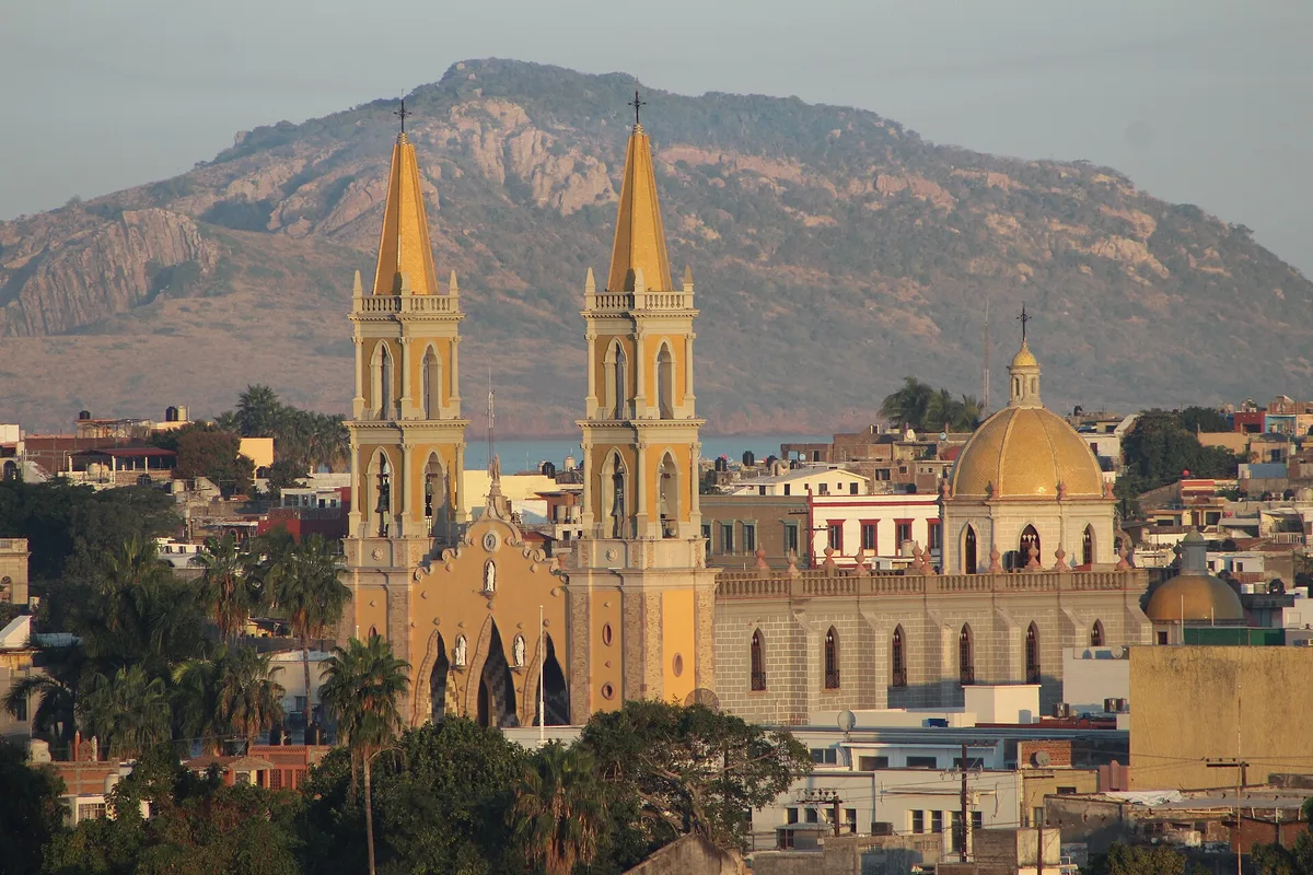 Mazatlán Cathedral and its twin golden towers above the Centro rooftops, hills behind