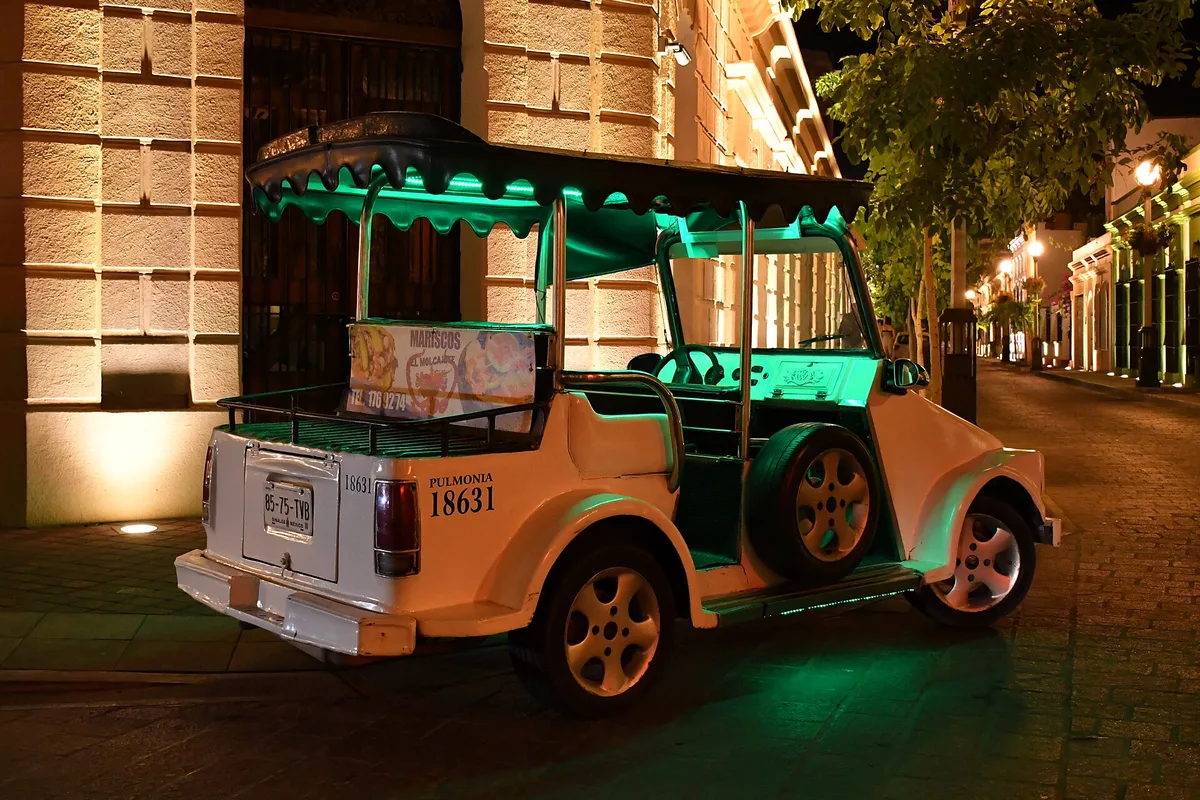 A pulmonía, Mazatlán's open-air taxi, lit up on a Centro street at night