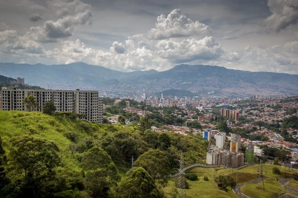 Medellin's rooftops and apartment blocks under green hills in the Aburra Valley