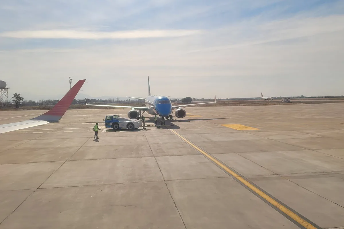 The tarmac at El Plumerillo, Mendoza's airport, with a plane at the stand and the control tower behind