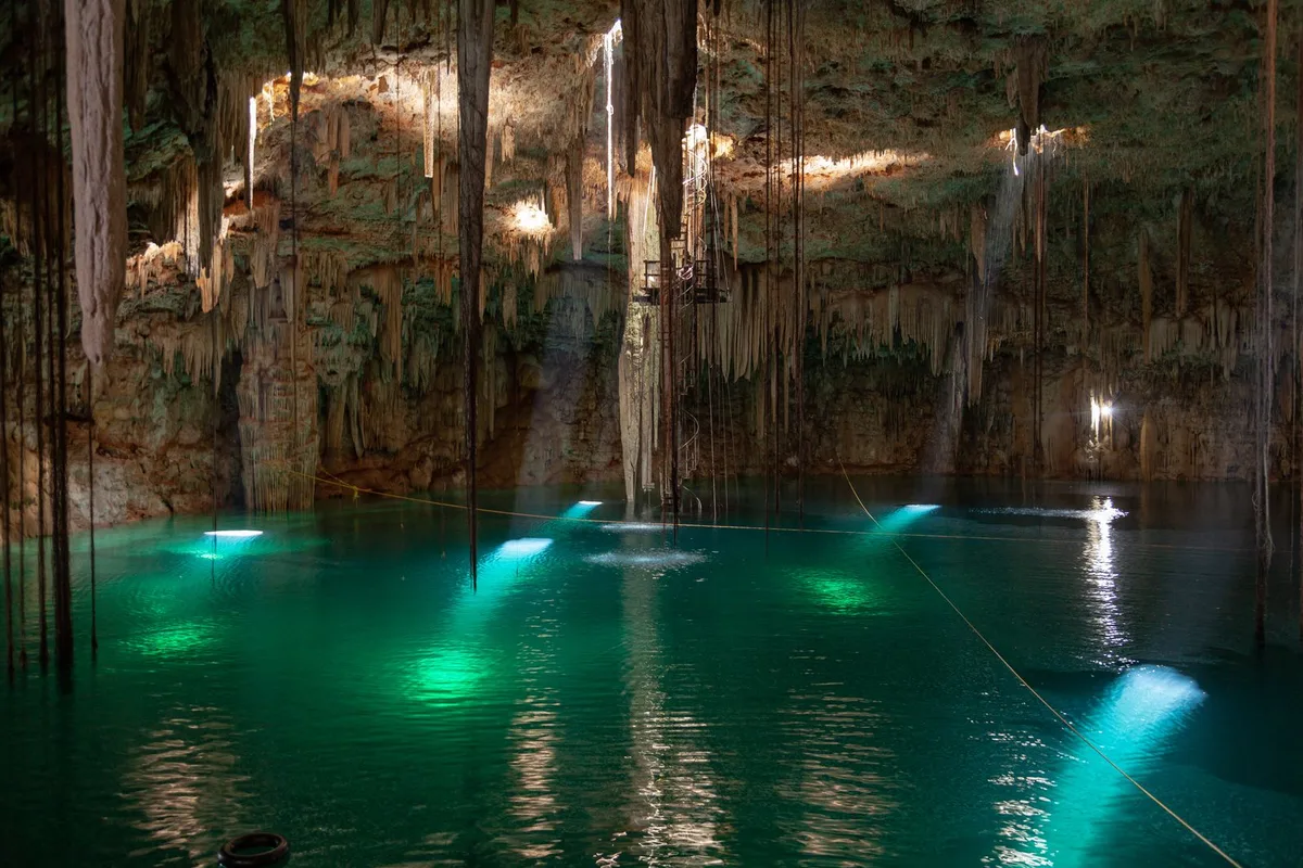 Sunlight falling into the turquoise water of a cave cenote