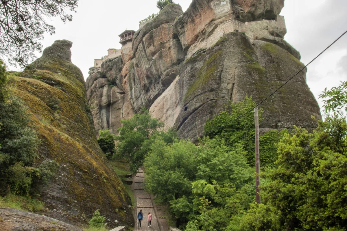 The cobbled monks' path climbing towards a monastery, walkers on the steps