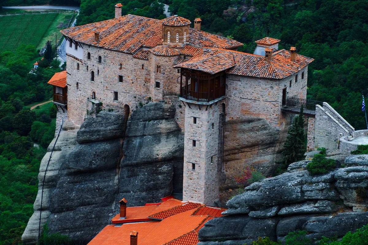 A visitor looking across the monasteries from a Meteora viewpoint