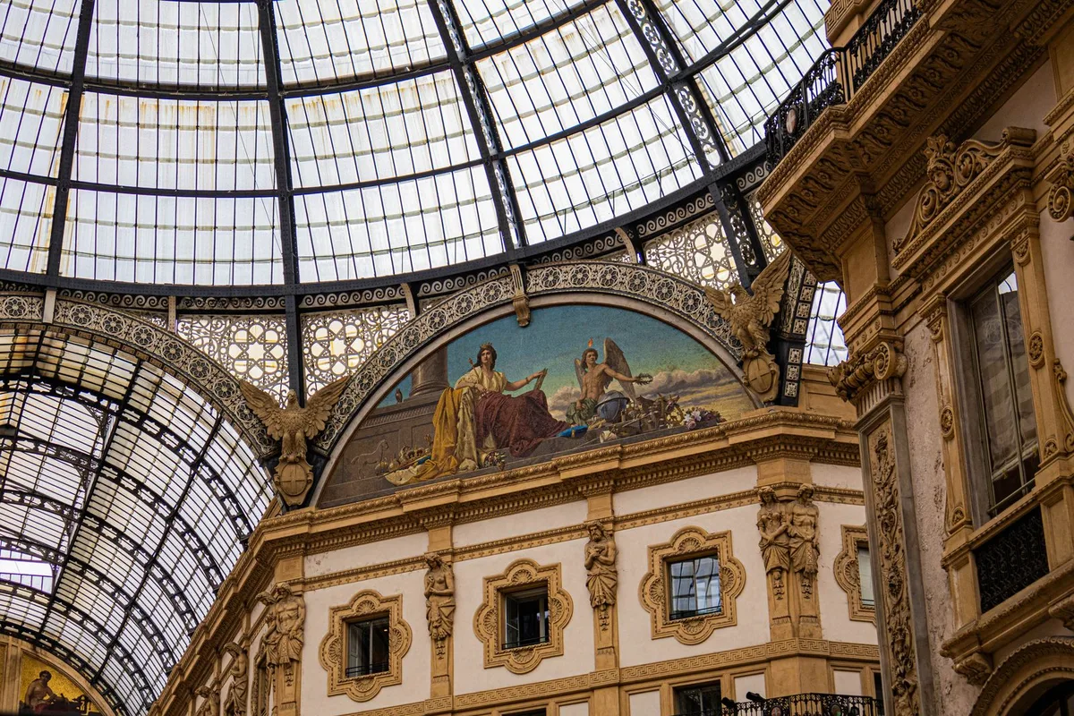 The Galleria Vittorio Emanuele II under its glass dome, shoppers crossing the mosaic floor