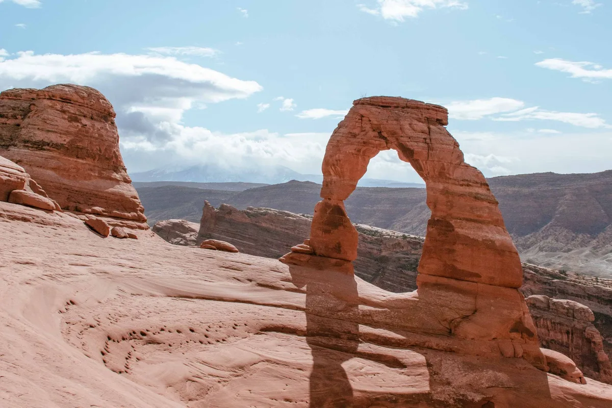 Delicate Arch standing alone above its sandstone bowl in late light