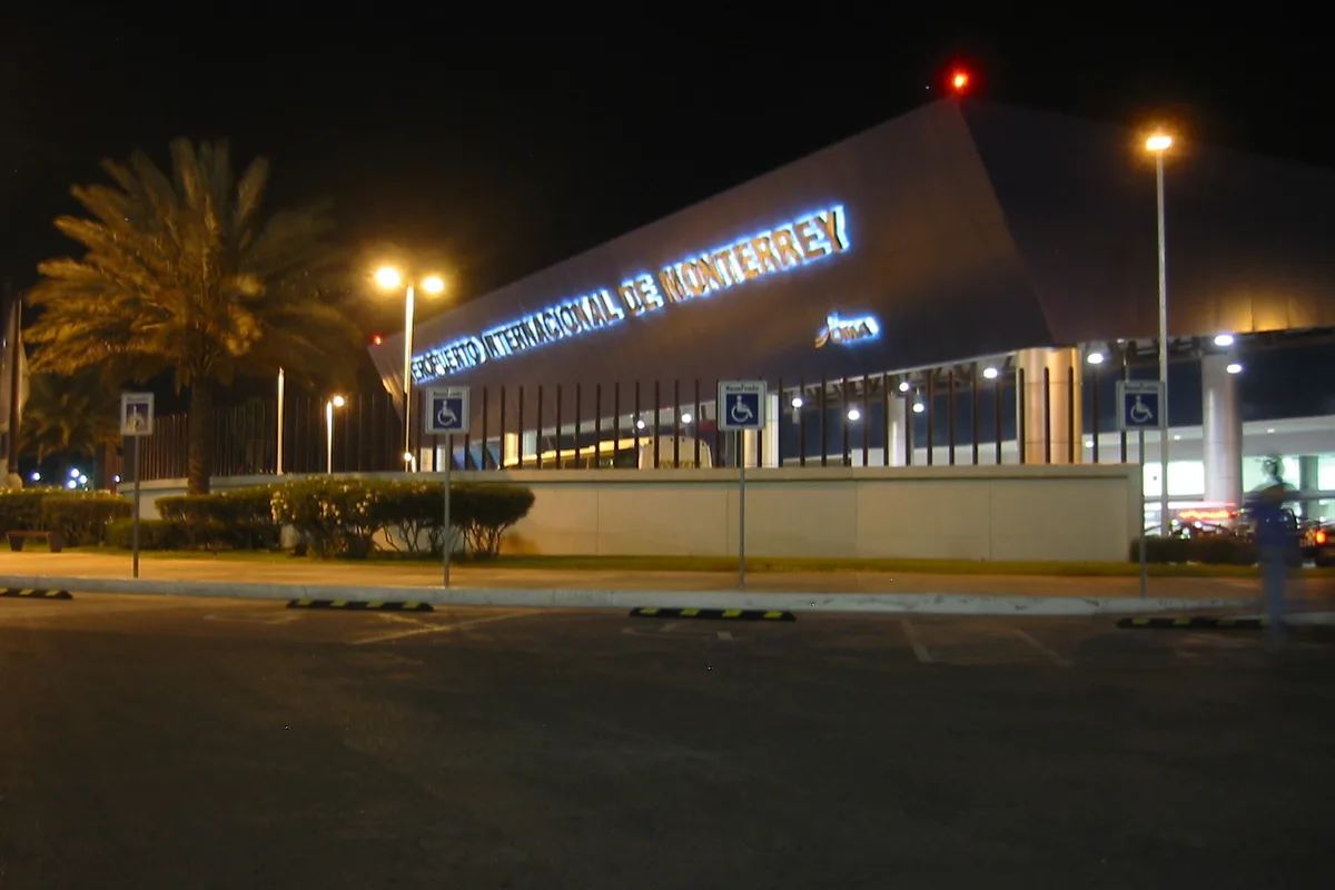 Monterrey International Airport terminal at night, its name lit above the entrance