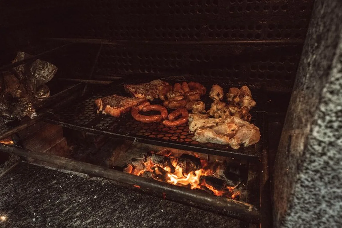 Meat and chorizos grilling over the wood fire of a Uruguayan parrilla