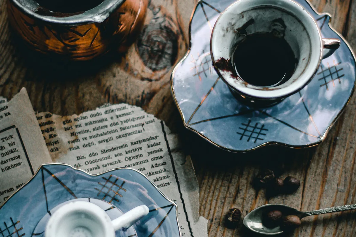 A copper džezva and fildžan cups of Bosnian coffee on a wooden table