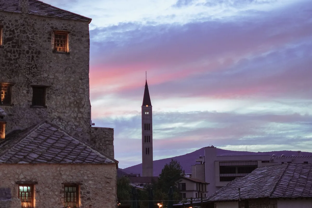 Mostar's Old Town at dusk, the minaret and stone roofs above the Neretva