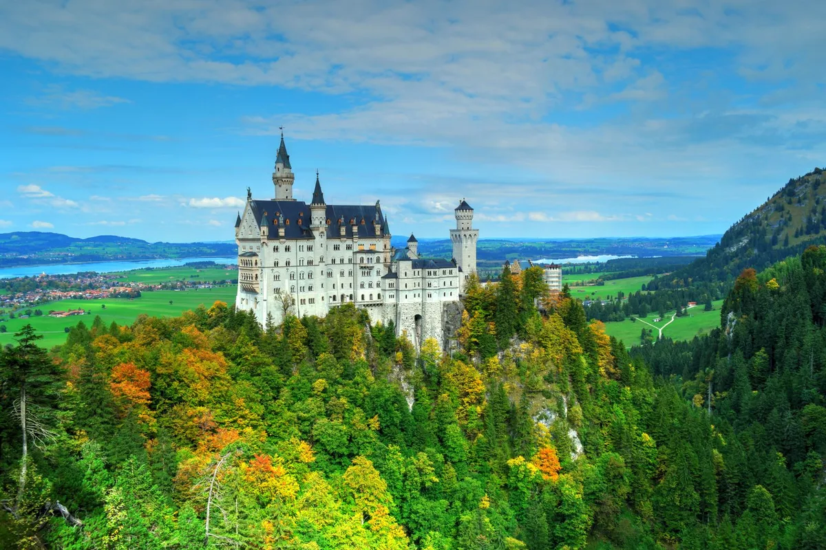 Neuschwanstein Castle above autumn trees in the foothills of the Bavarian Alps