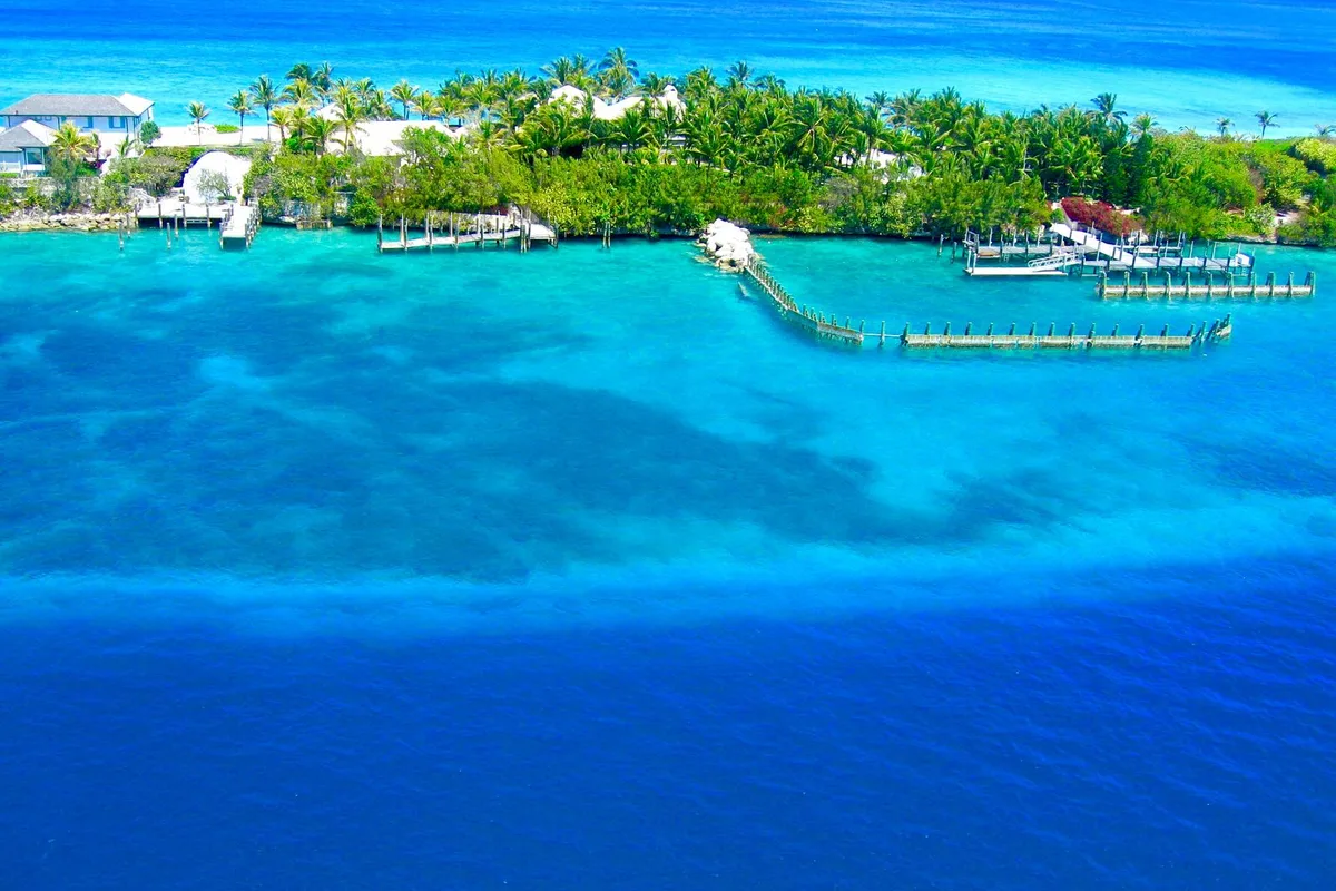 An aerial view of Nassau Harbour, its turquoise water, docks and green shoreline