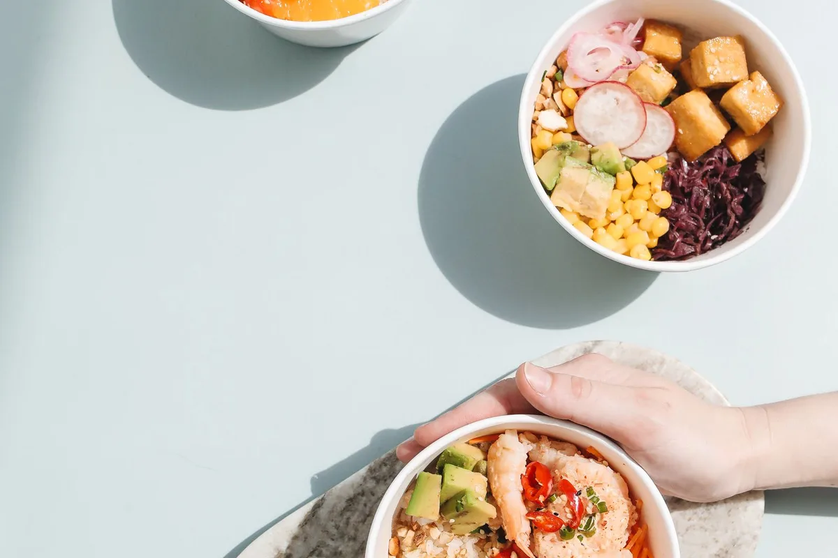 Poke bowls of cubed raw fish over rice, seen from above