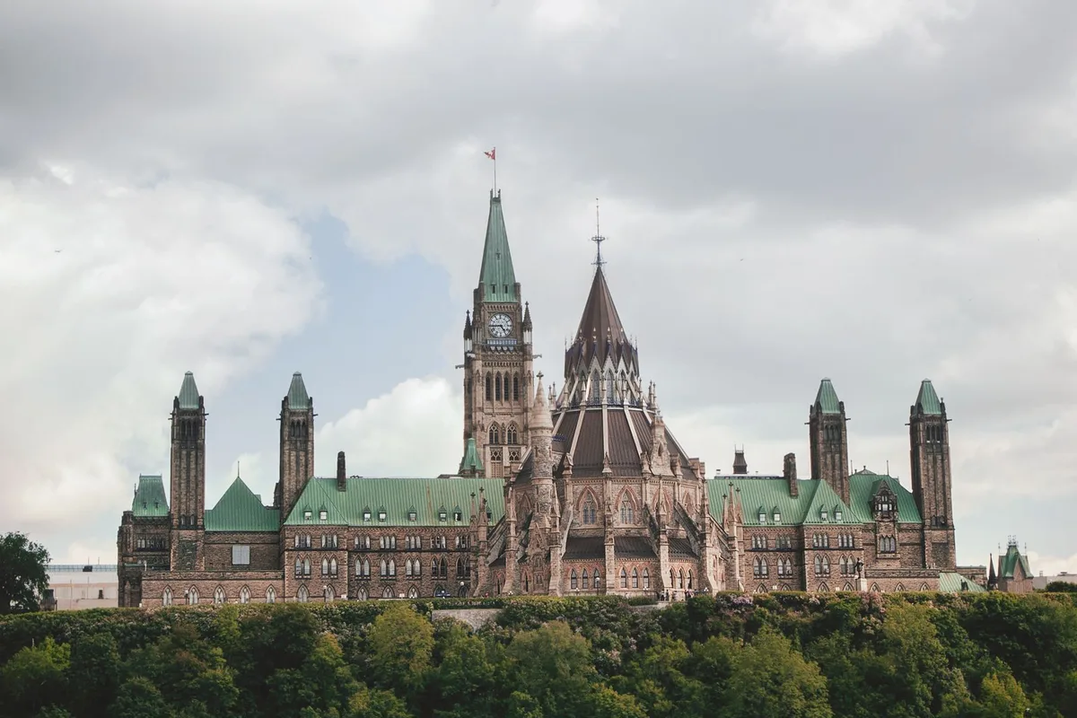 Parliament Hill in Ottawa from across the river, its green-roofed buildings above the treeline