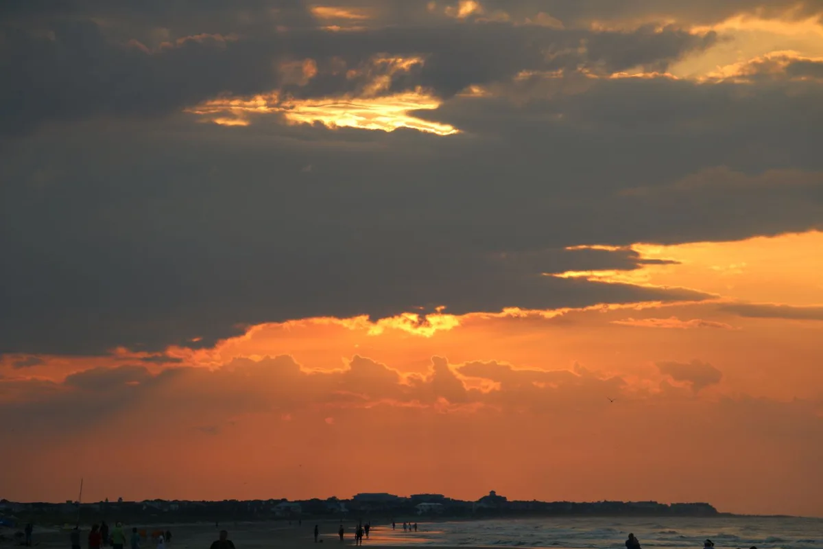 Sunset over the water on the Outer Banks, silhouetted figures on the shore