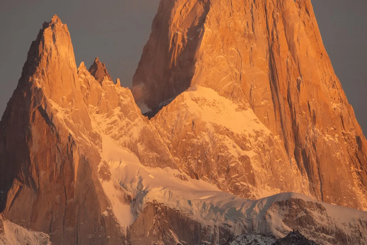 Mount Fitz Roy glowing gold above El Chaltén at sunrise