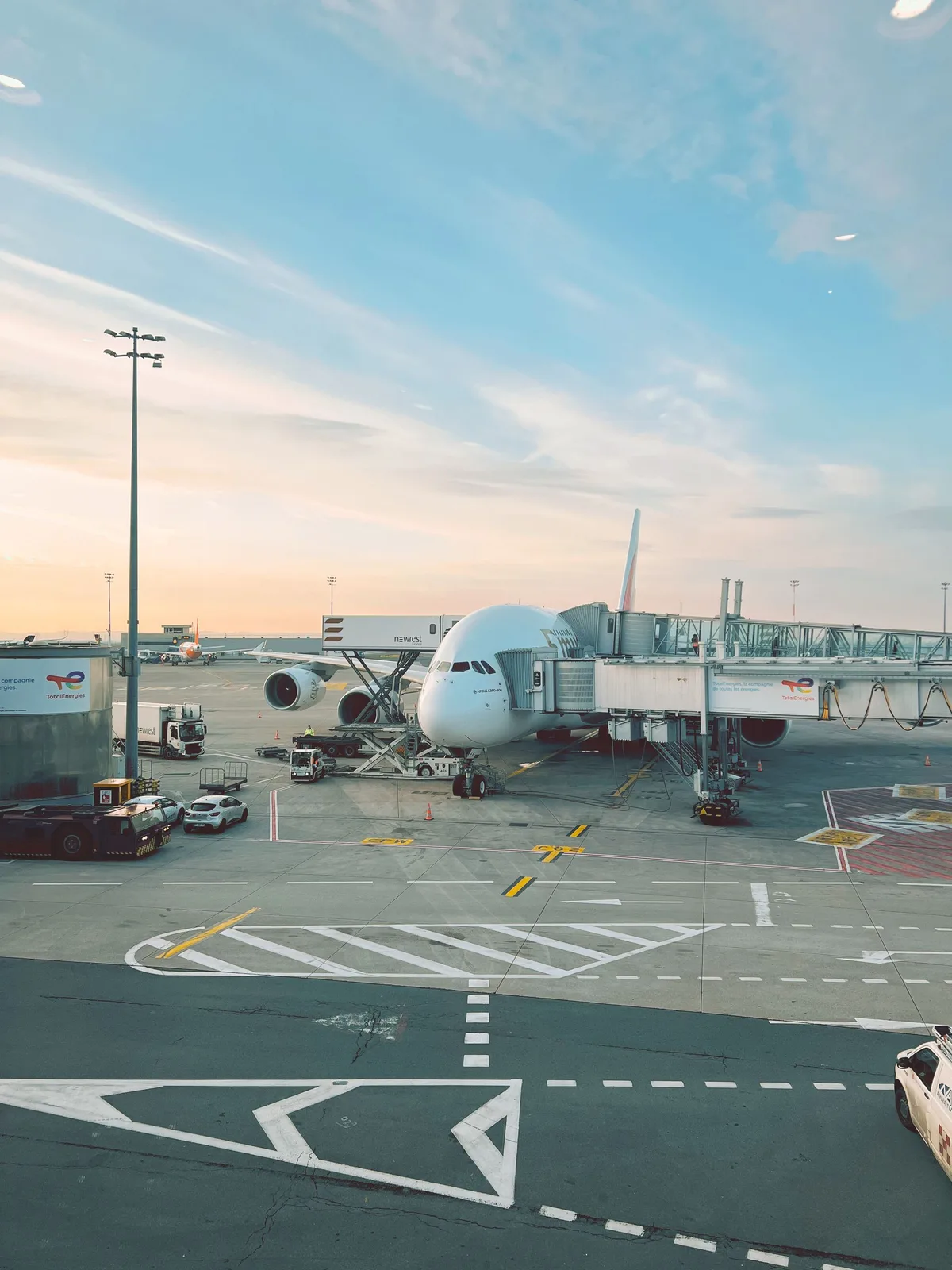 A wide-body jet at the gate at sunrise