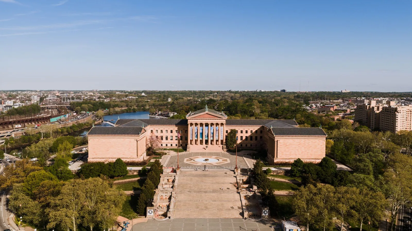 the Philadelphia Museum of Art from across its plaza, the Rocky steps in front and the Schuylkill River behind