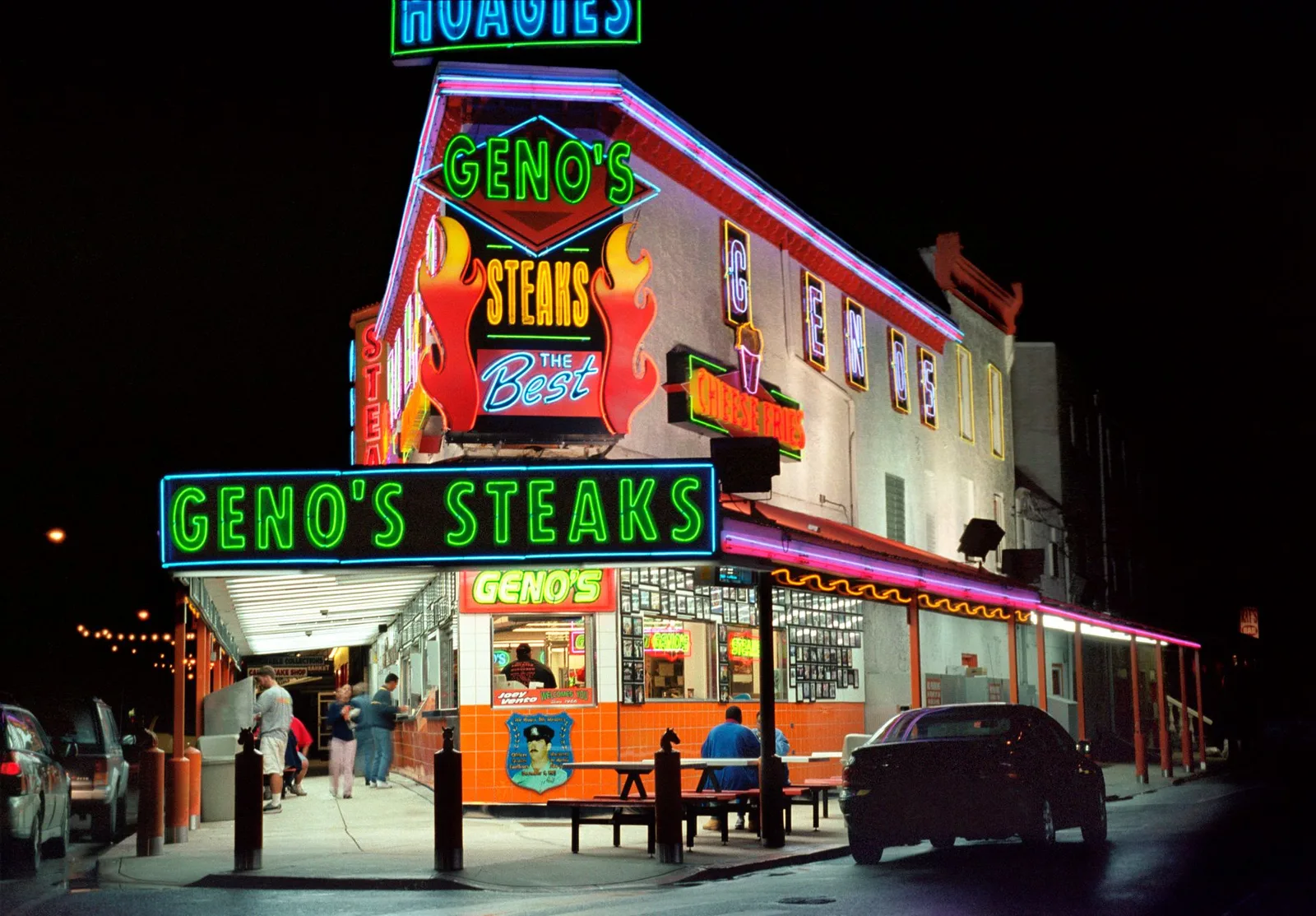 Geno's Steaks in South Philadelphia at night, blazing with green and pink neon
