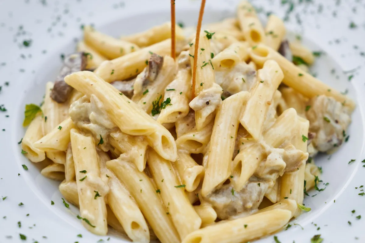 A plate of penne in a creamy mushroom sauce, served trattoria-style