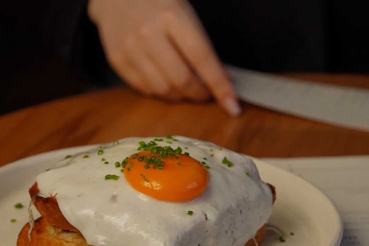 A francesinha sandwich under melted cheese and hot beer and tomato sauce