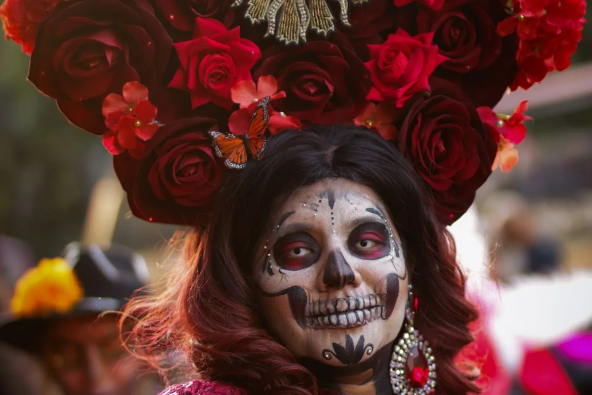 A woman in Day of the Dead catrina dress and floral headdress in Puebla