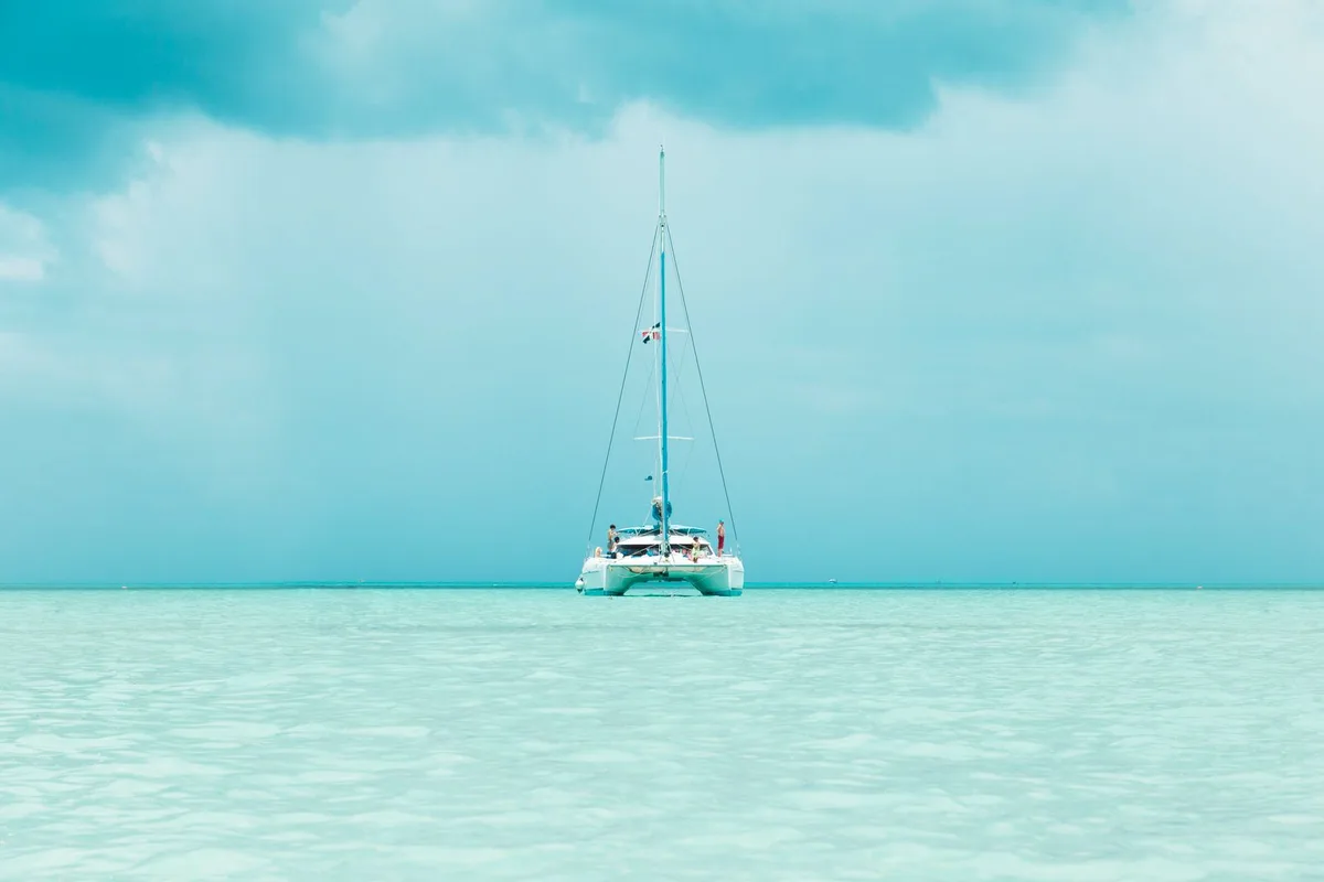 A catamaran anchored on calm turquoise water off Saona Island
