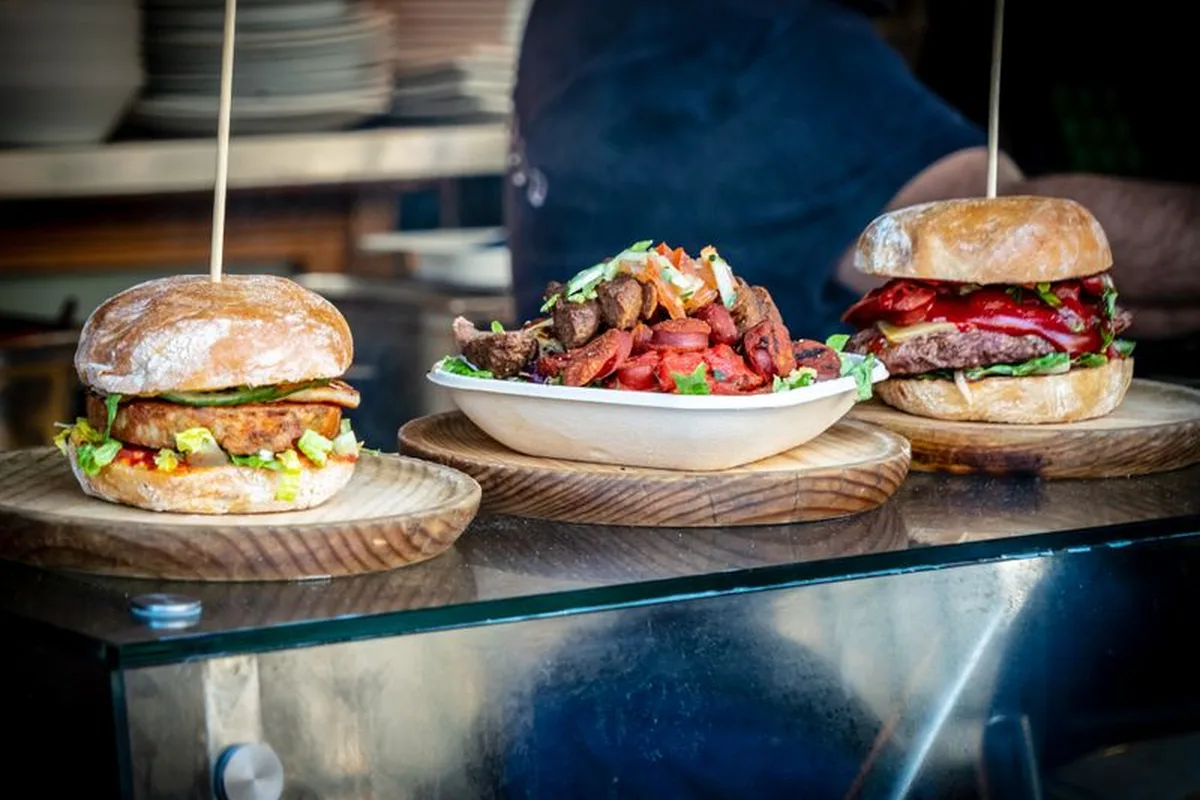 Burgers and loaded fries served on wooden boards at a Queenstown counter
