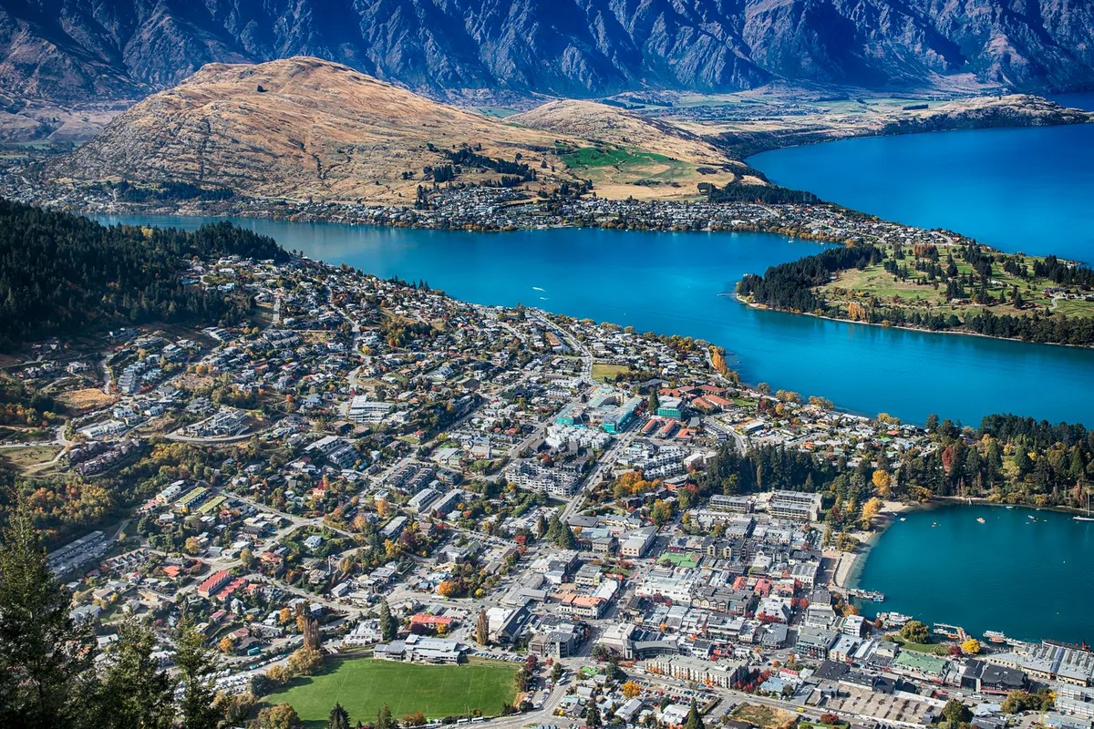Queenstown and Lake Wakatipu from above, the town spread along the bay below the mountains
