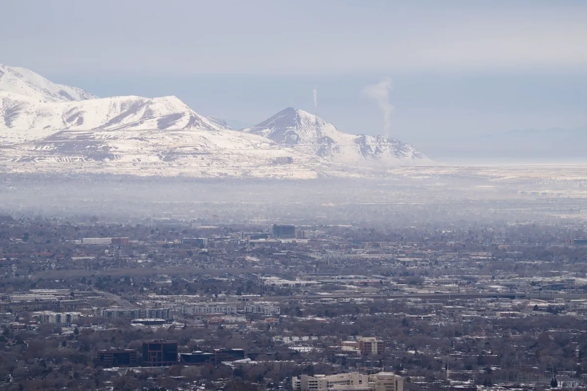 Winter inversion haze over Salt Lake City with snowy Wasatch peaks behind