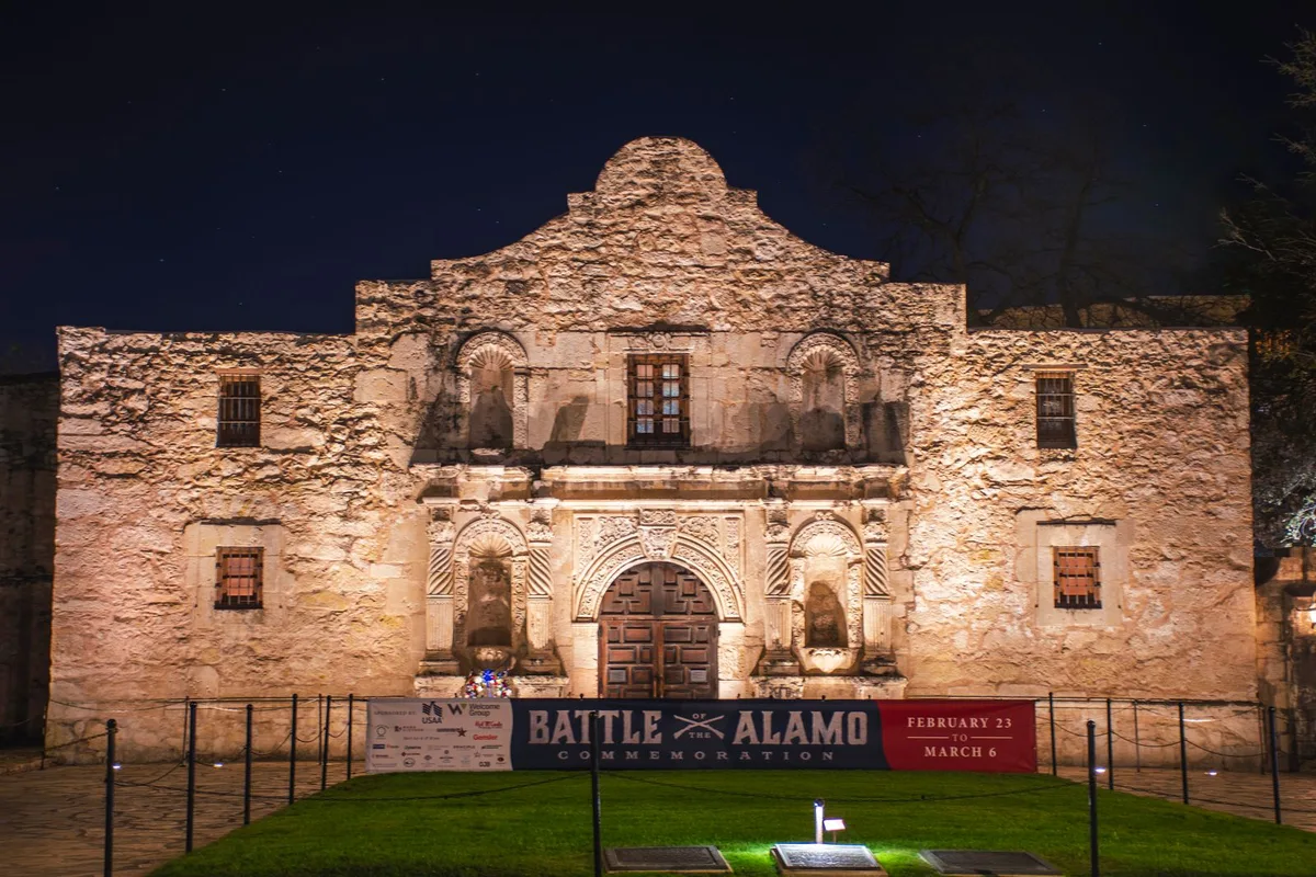 The Alamo church facade lit up at night