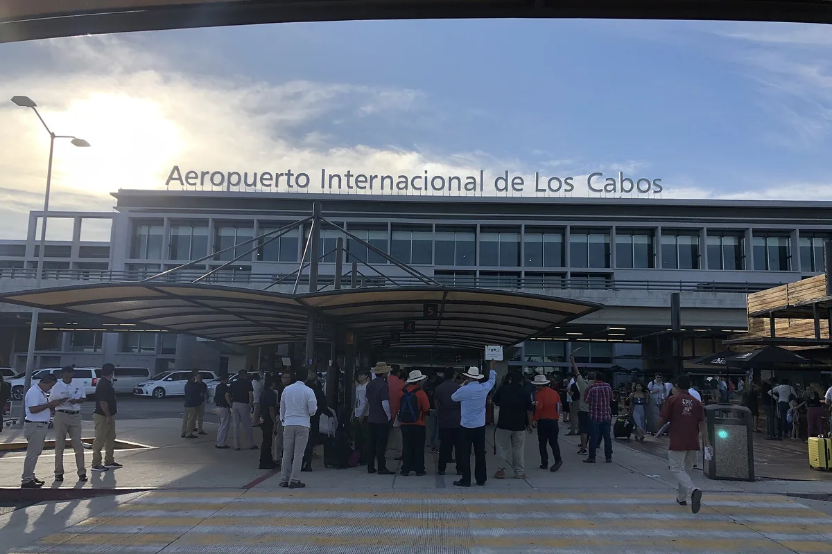Passengers outside the terminal at Los Cabos International Airport (SJD), the name over the doors
