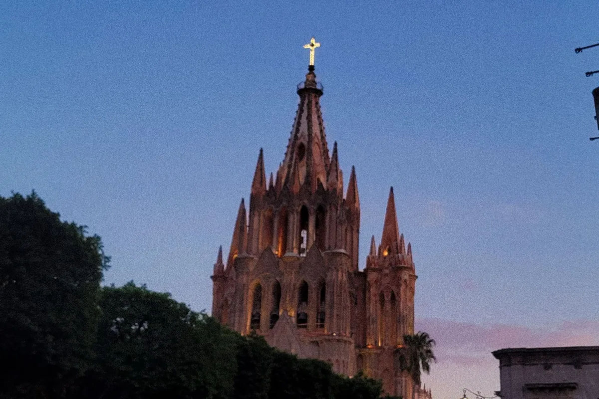 The Parroquia de San Miguel Arcángel at dusk against a deep blue sky