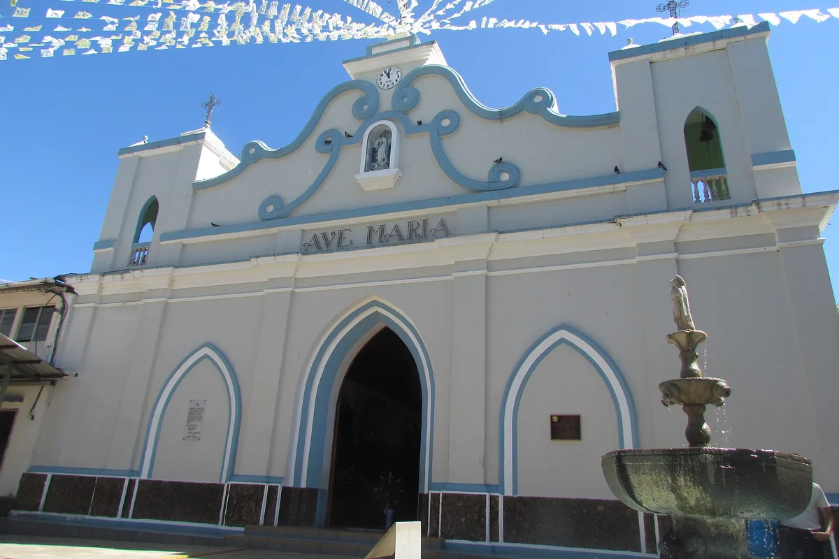 The white and blue facade of the church at Concepción de Ataco, fountain in front, on the Ruta de las Flores