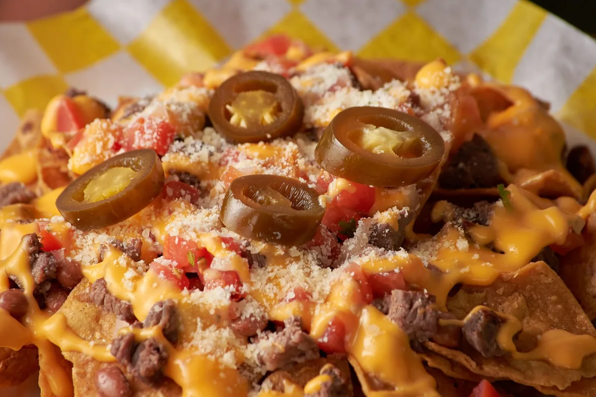 A loaded plate of nachos with jalapeños, cheese and pico de gallo, New Mexican style