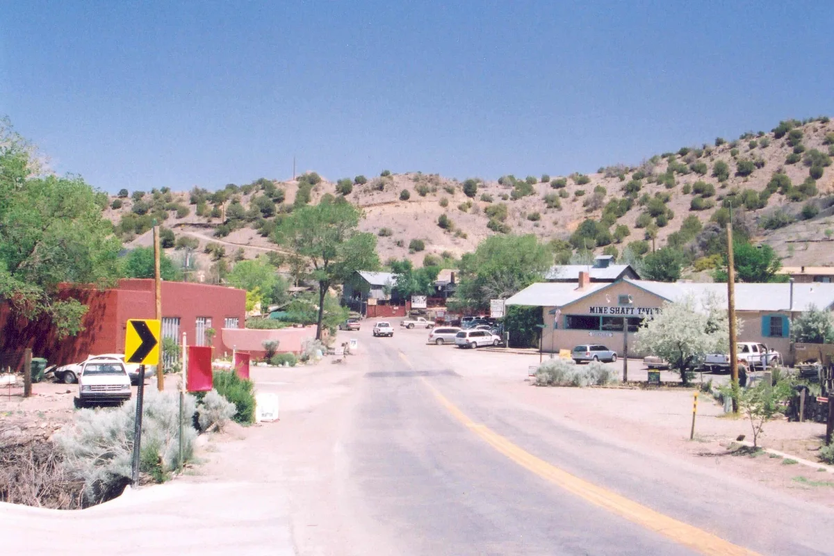Main Street in Madrid, New Mexico, low adobe and timber storefronts along the Turquoise Trail