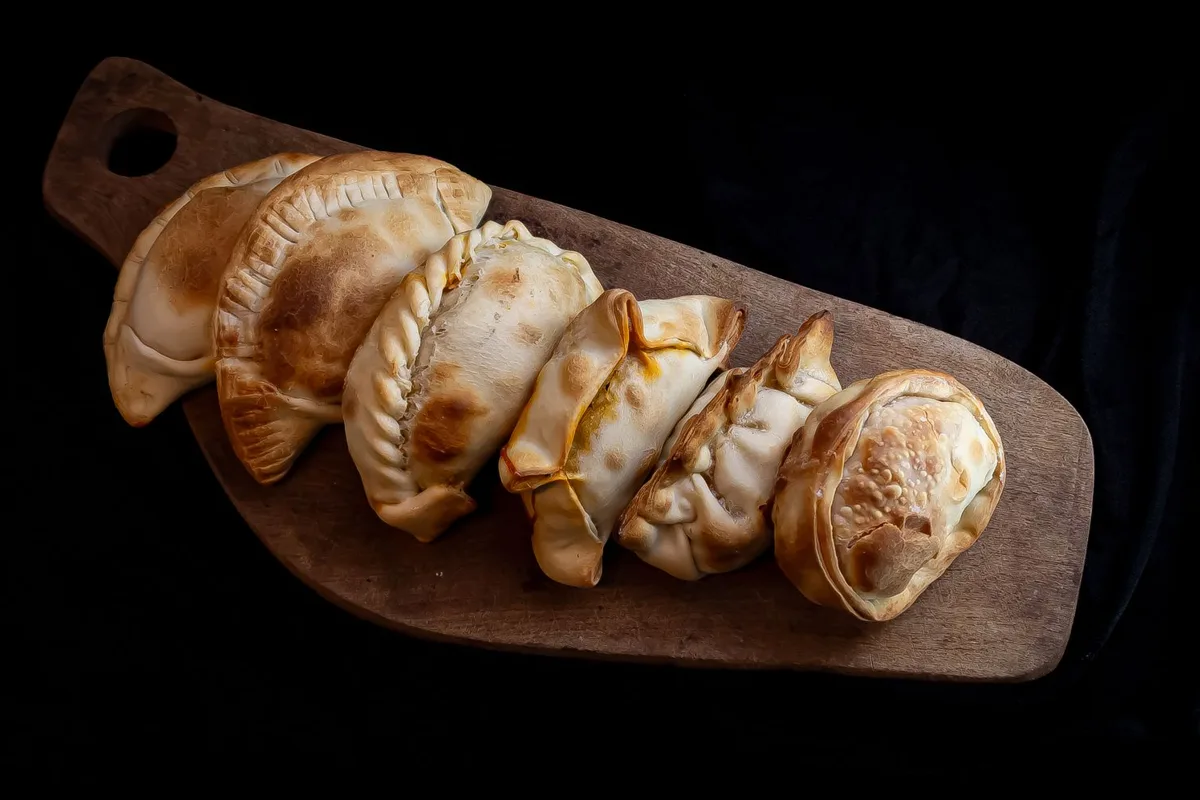 Freshly baked empanadas on a wooden board