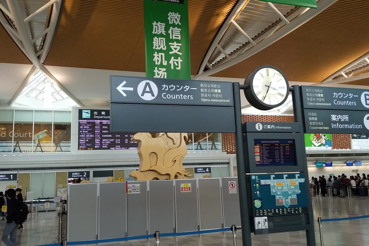 Inside the international terminal at New Chitose Airport, check-in counters and departure signs