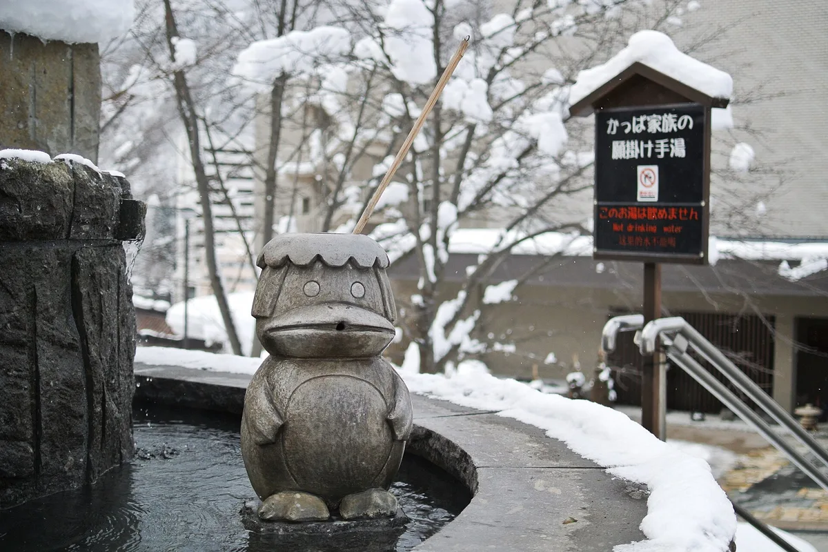 A kappa statue at a steaming hand bath in snowy Jozankei Onsen