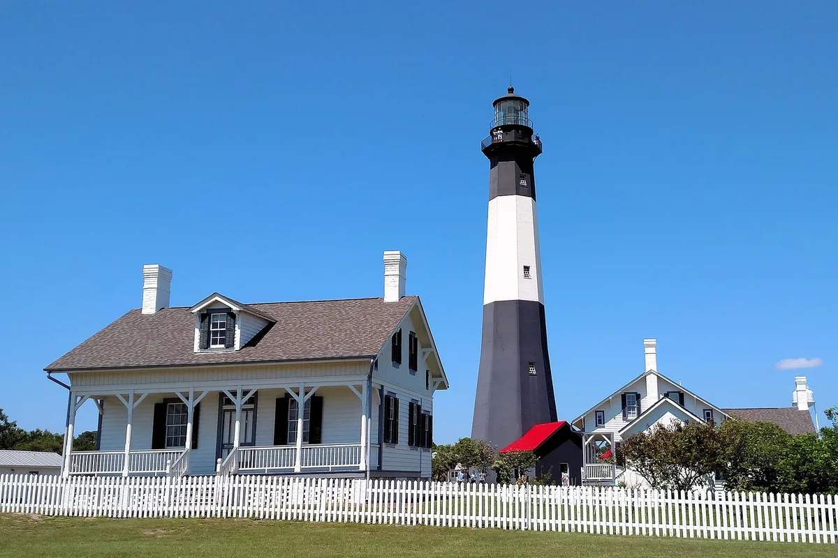 Tybee Island's black and white lighthouse above the beach