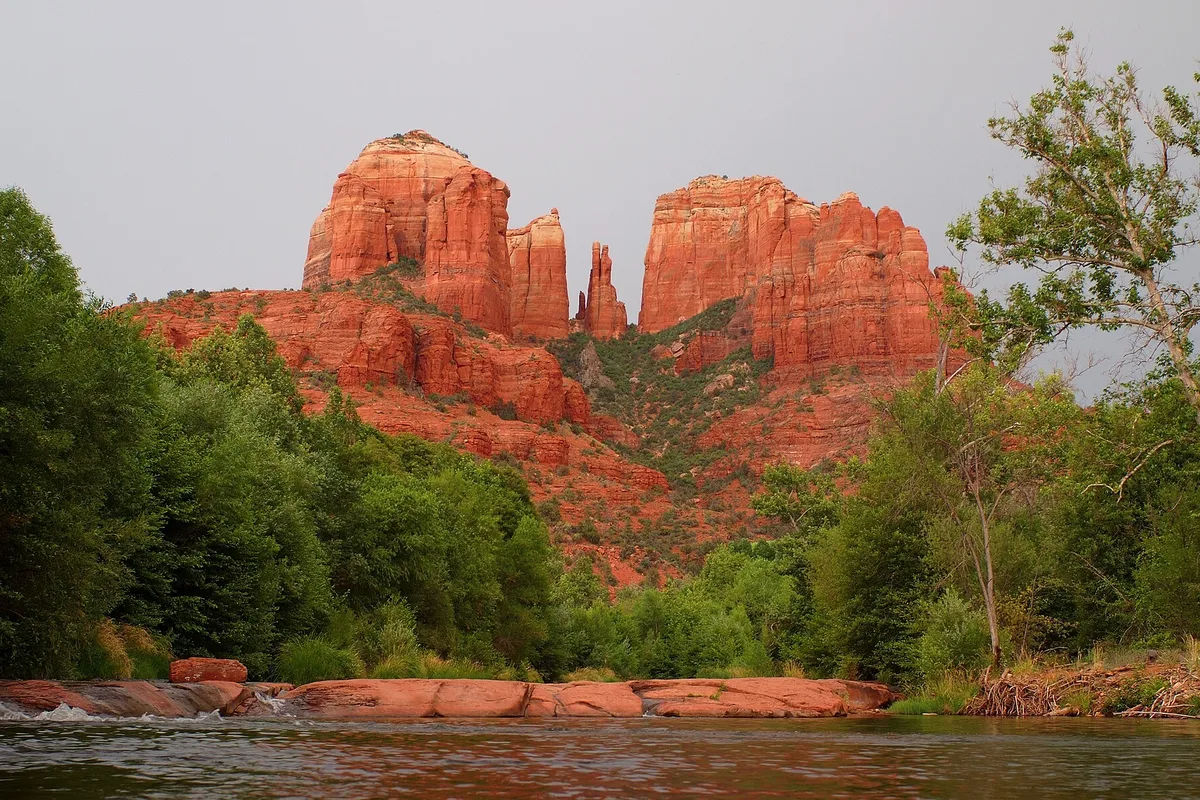 Cathedral Rock above Oak Creek in Sedona, red sandstone towers over green cottonwoods