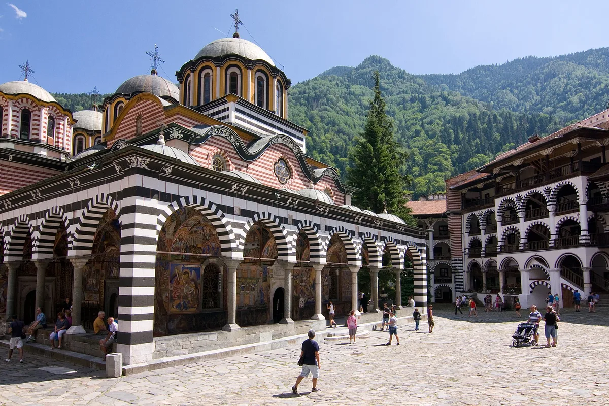 The frescoed church and striped arcades of Rila Monastery, in its mountain courtyard