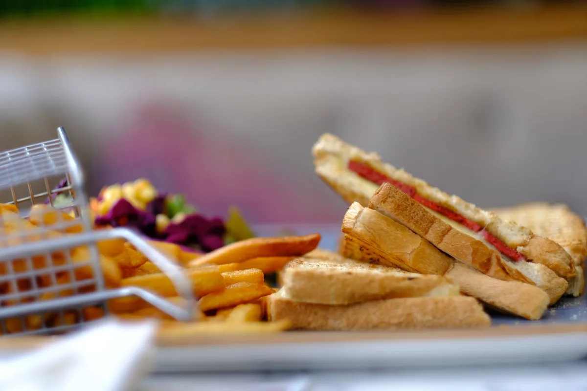 A pressed Cuban sandwich, cut in triangles, with fries alongside